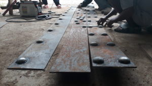 workers welding rivets in rusty iron design in taling gnam, koh samui